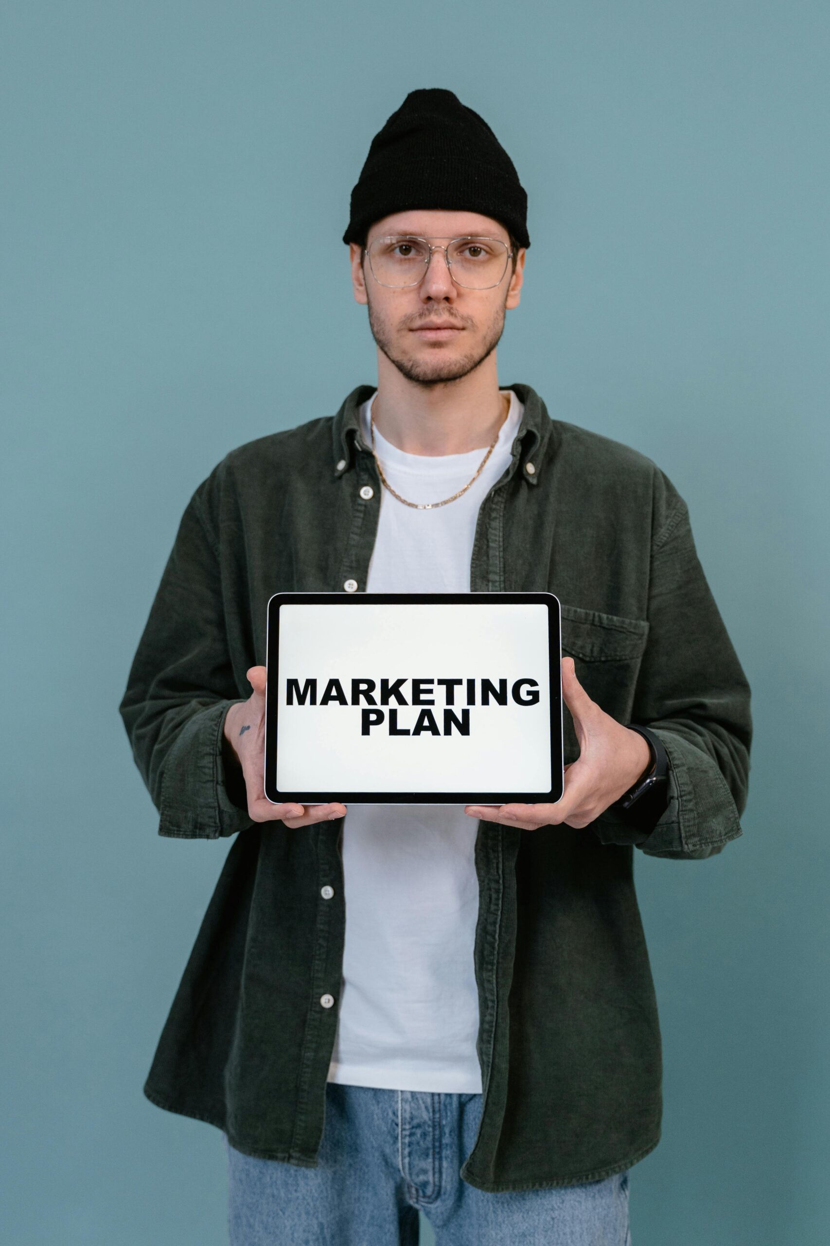 A man is standing with a marketing plan template for digital marketing agency in delhi in a light blue background